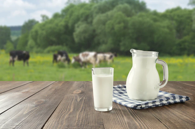 fresh-milk-glass-dark-wooden-table-blurred-landscape-with-cow-meadow-healthy-eating-rustic-style_91908-1026