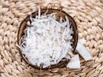 Heap of Grated Coconut (close-up shot) on wooden background